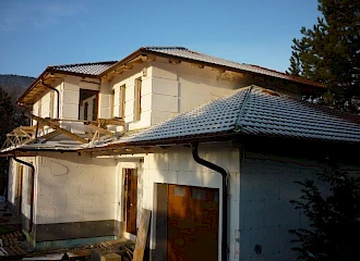Korszerű és családias lakóépület: készül a homlokzat diszítés, és a tető is